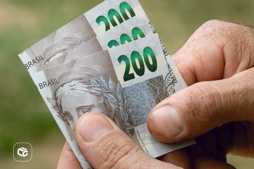Mão segurando notas de 200 reais do Brasil