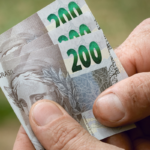 Mão segurando notas de 200 reais do Brasil