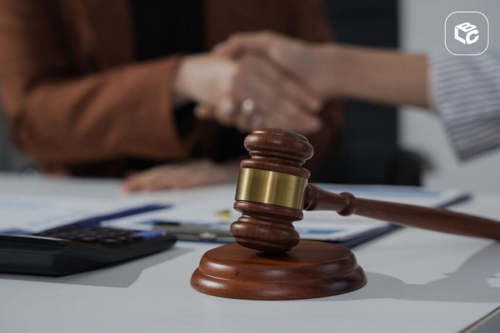 Martelo de juiz e aperto de mãos simbolizando acordo legal